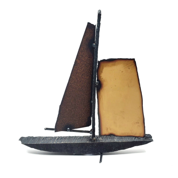 Bateau - Medium boat of welded repurposed iron. The sails are red and silver on one side, and orange and rust on the other.