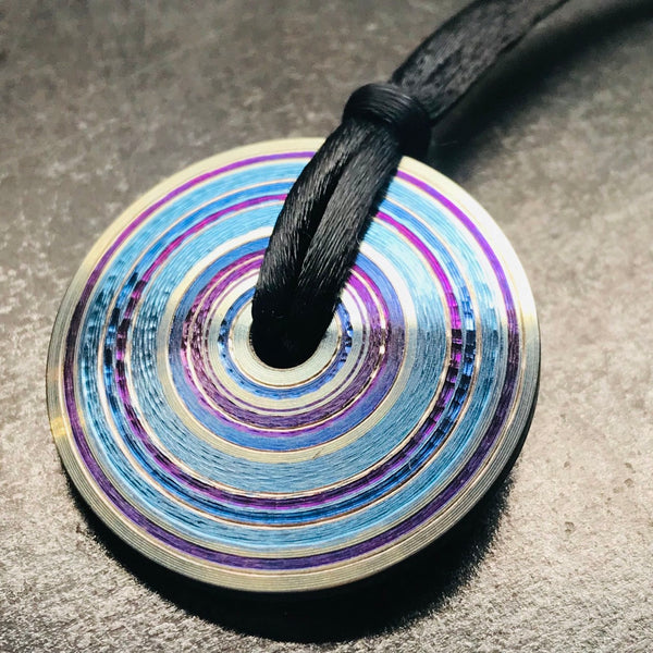 Chroma: pendant of purple, blue, and steel-grey lathed and anodized titanium