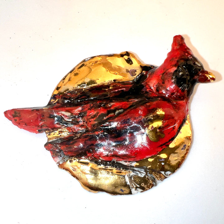 Small cardinal porcelain pin with gold lustre.