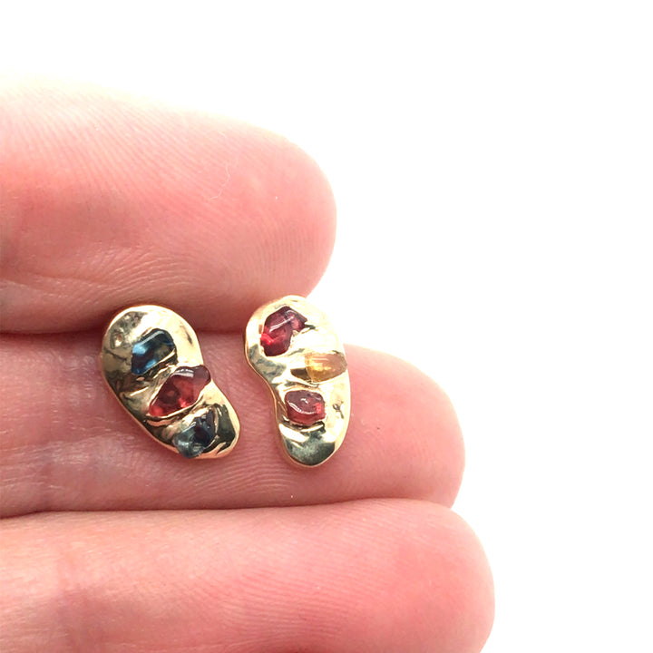 Asymmetrical 14k stud earrings gorgeously studded with colourful rough sapphires.