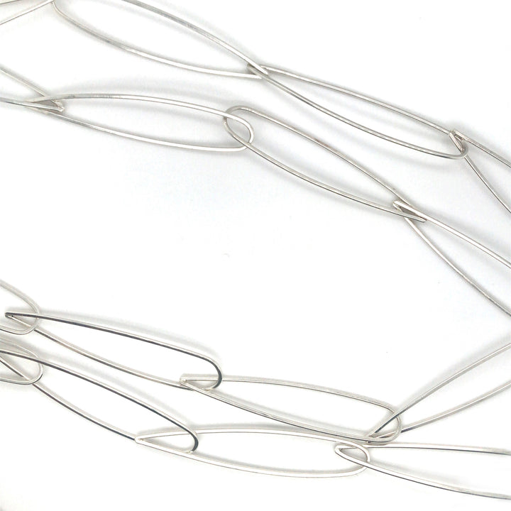 Long leaf link necklace of hand fabricated sterling silver. Each link is shaped like an elongated leaf, or teardrop. 42" length.