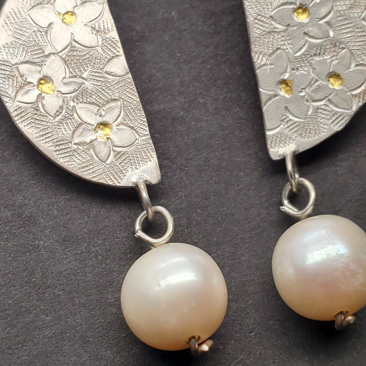 Hand-tooled fine silver stud earrings, with keum-boo gold (24k) worked into the surface. 10mm freshwater pearls hang from the flower-patterned semi-circles.