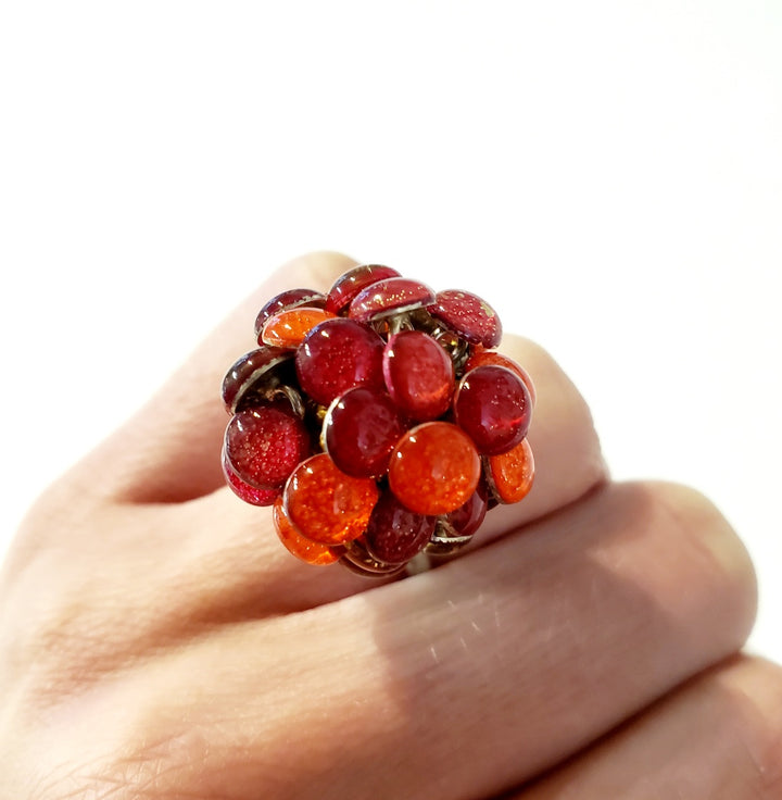 Round Red Resin Ring. Droplets of red resin and sterling silver are sewn in with golden yellow thread. This 2.2cm x 2.2cm centerpiece sits on a size 6.5 sterling silver shank.