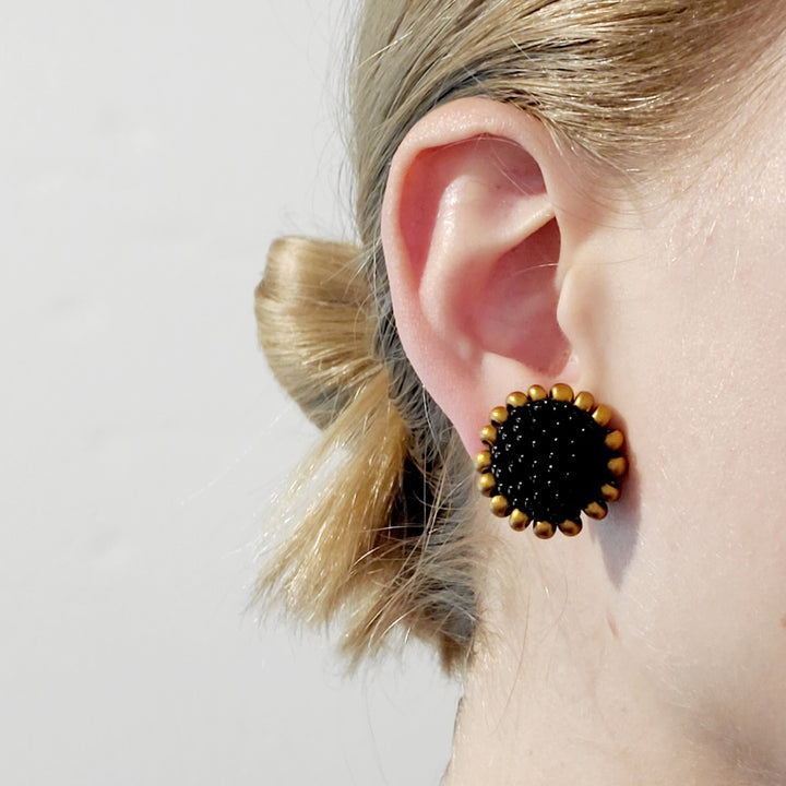 Black and Gold Clip-On Earrings. Black and gold glass beads are sewn in with black thread. These earrings measure 2.3cm in diameter, and have sterling silver clips.