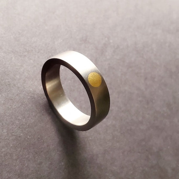 Gold Dot Ring (24k) set into a flat fit titanium band that is 6 mm wide and fits a size 9.