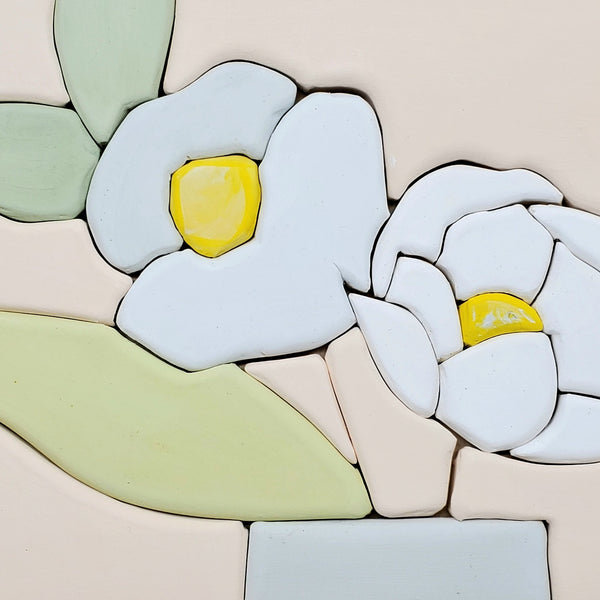 Comfort - Hand molded clay coloured pieces within a solid wood frame, depicting a still life of pale blue flowers with yellow centers.  Measures 25 x 25 x 2.5 cm