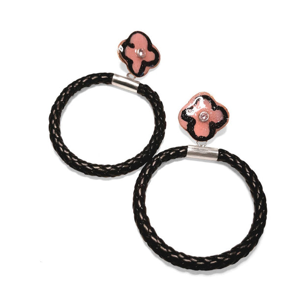Small flower hoop dangle earrings. Bold earrings featuring a braided faux leather hoop capped with sterling silver that dangles from a pink flower stud. The glitter resin-decorated copper studs are centered with pink cubic zirconia stones, and have sterling silver posts.
