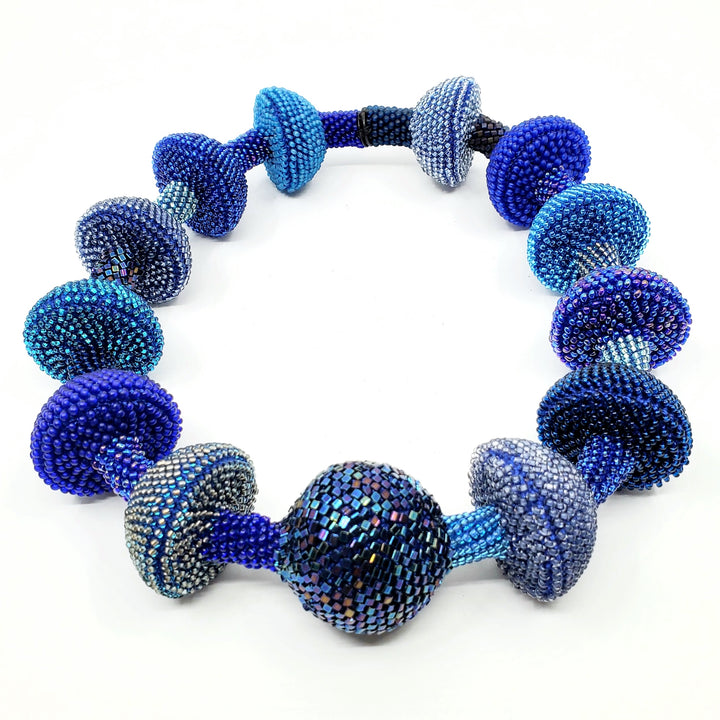 Yael Krakowski Blue Mushroom necklace with glass beads, and thread.