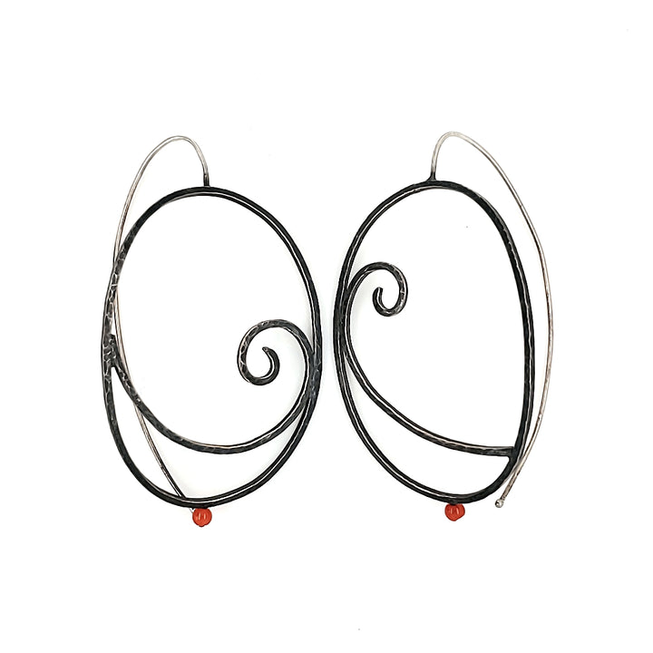  "Art Déco" earrings are large sterling silver hoops with punctuated with a red-orange coral bead.