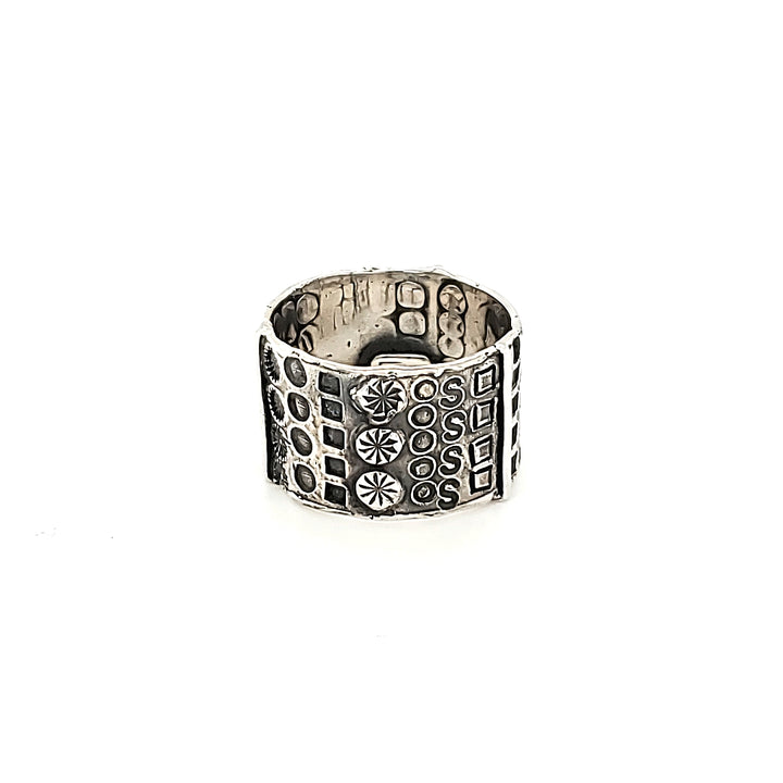 "Hommage à Walter Schluep" : Wide 13mm sterling silver band with stamped patterns circling the entire form. The stamped patterns can be seen also on the inside of the band.