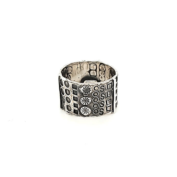 "Hommage à Walter Schluep" : Wide 13mm sterling silver band with stamped patterns circling the entire form. The stamped patterns can be seen also on the inside of the band.