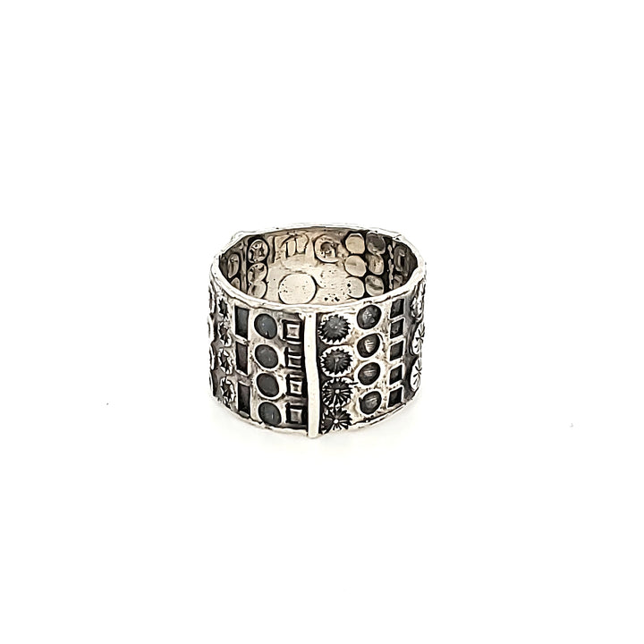 "Hommage à Walter Schluep" : Wide 13mm sterling silver band with stamped patterns circling the entire form. The stamped patterns can be seen also on the inside of the band.