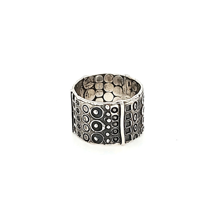 "Hommage à Walter Schluep" : Wide 13mm sterling silver band with stamped patterns circling the entire form. The stamped patterns can be seen also on the inside of the band.