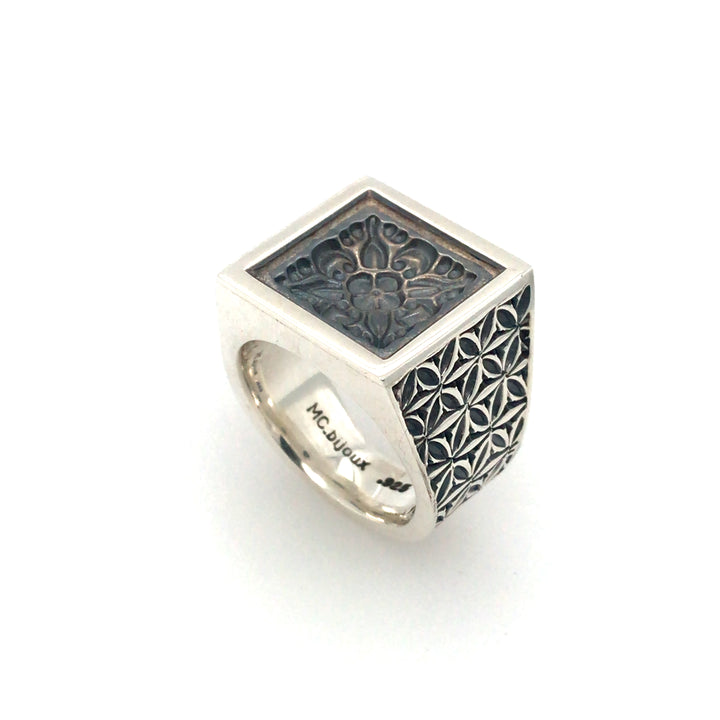 Sterling silver signet ring with a medallion emblem based on a Nepalese stamp, cast and finished with a matte oxide. Size 10.25. 