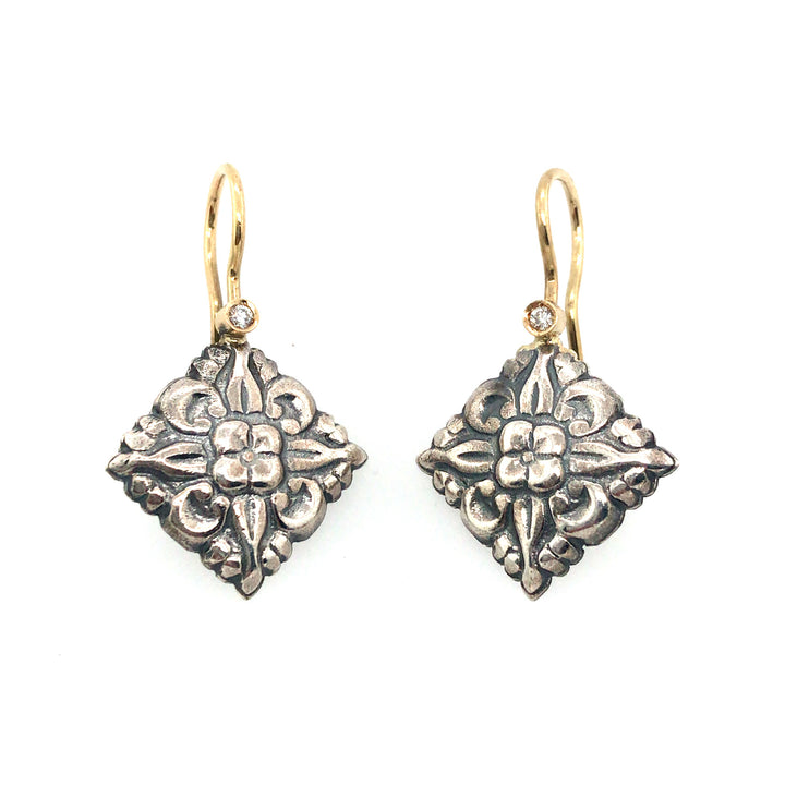 Stamped sterling silver earrings with diamonds set in 18k gold, with gold ear hooks.