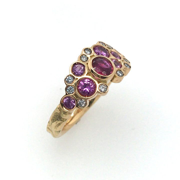 Phenomenal pink sapphires and diamonds sparkle in this floral 18k yellow gold band. Size 8.