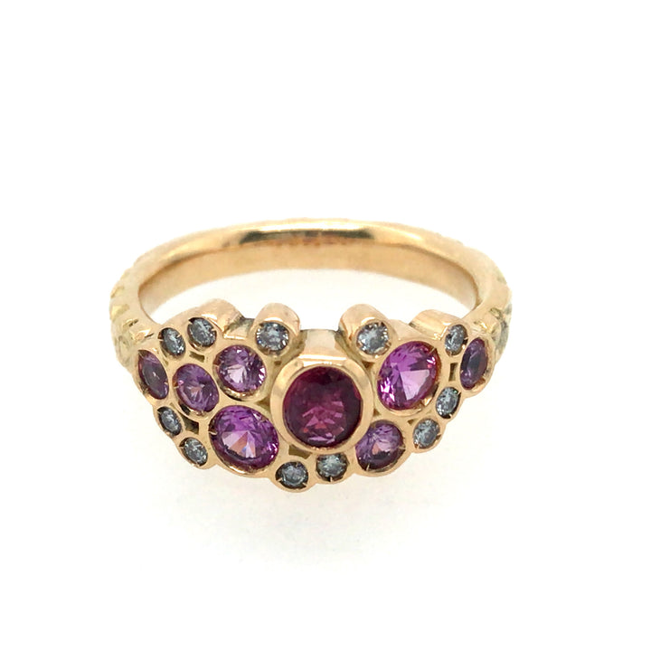 Phenomenal pink sapphires and diamonds sparkle in this floral 18k yellow gold band. Size 8.