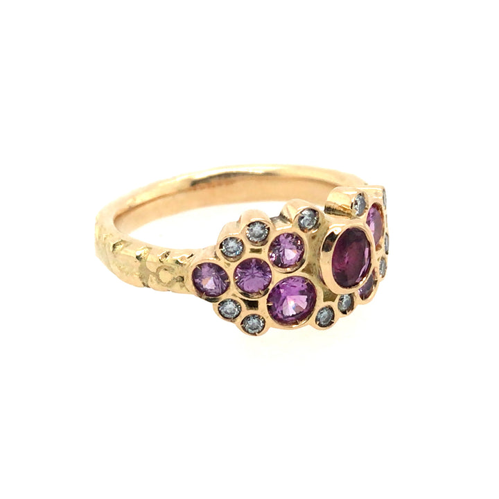 Phenomenal pink sapphires and diamonds sparkle in this floral 18k yellow gold band. Size 8.
