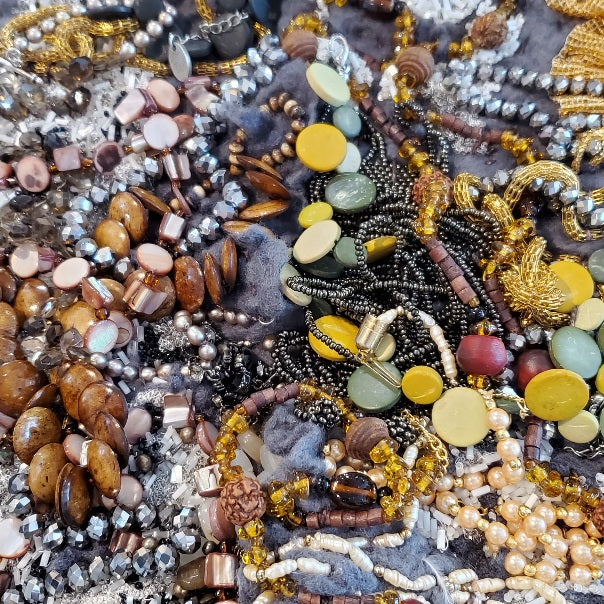 This shimmering felted neckpiece incorporates swatches of beaded fabrics and jewellery to make a bold statement. The grey felted underside is soft against the skin, with a comfortable weight.