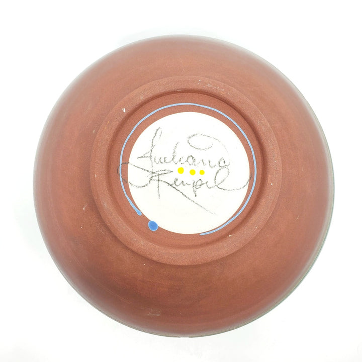 Large green ceramic salad bowl with a tactile decorated surface revealing the red clay. The interior is glazed white.
