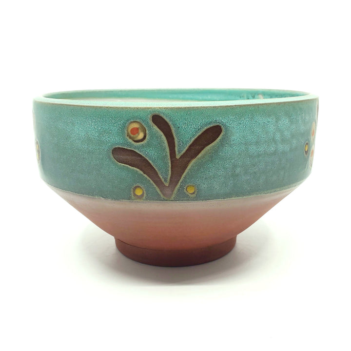 Large green ceramic salad bowl with a tactile decorated surface revealing the red clay. The interior is glazed white.