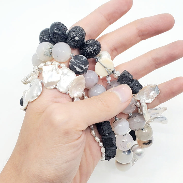 Multi-strand necklace of lava stones, agate, and baroque pearls, hand-knotted between each bead, with a sterling silver clasp.