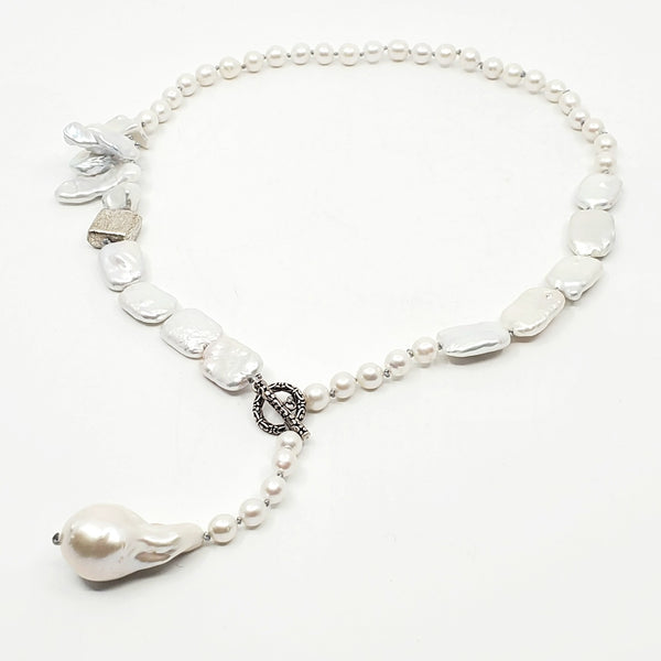 Multi-strand pearl necklace, hand-knotted between each pearl, with a sterling silver clasp.