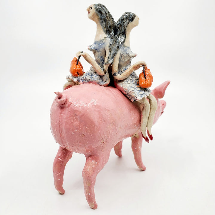 To Market, To Market: Ceramic figure of a pig with twin witches on its back, each holding orange purses.