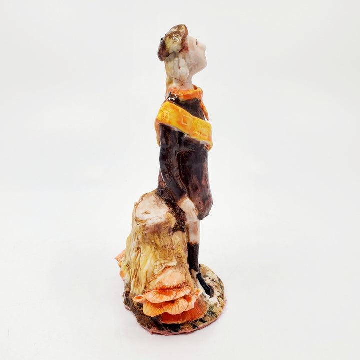 Foraging Badge: Little Girl Scout standing next to a tree stump with chicken of the woods growing around its base. She bears a blade, at the ready.