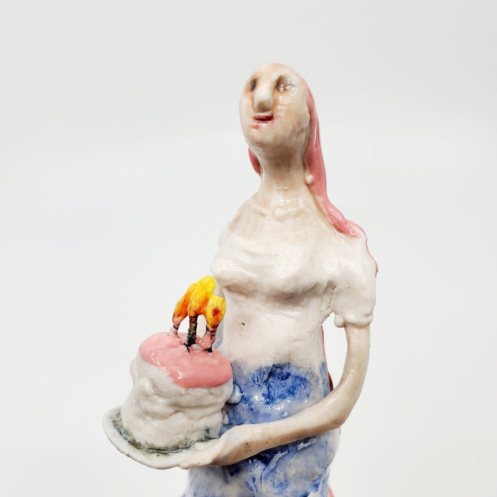 Cake Wife: Two-part ceramic sculpture of a woman holding a cake, and an oven. Designed to hang on the wall, each hangs separately from a metal loop.