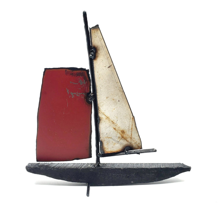 Bateau - Medium boat of welded repurposed iron. The sails are red and silver on one side, and orange and rust on the other.