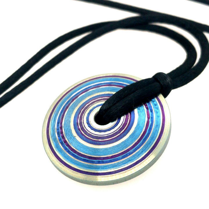 Chroma: pendant of purple, blue, and steel-grey lathed and anodized titanium