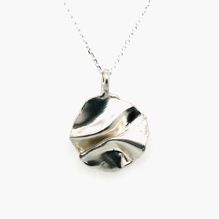 Fold, small round sterling silver pendant (around 2 cm in diameter) on an 18" fine chain.
