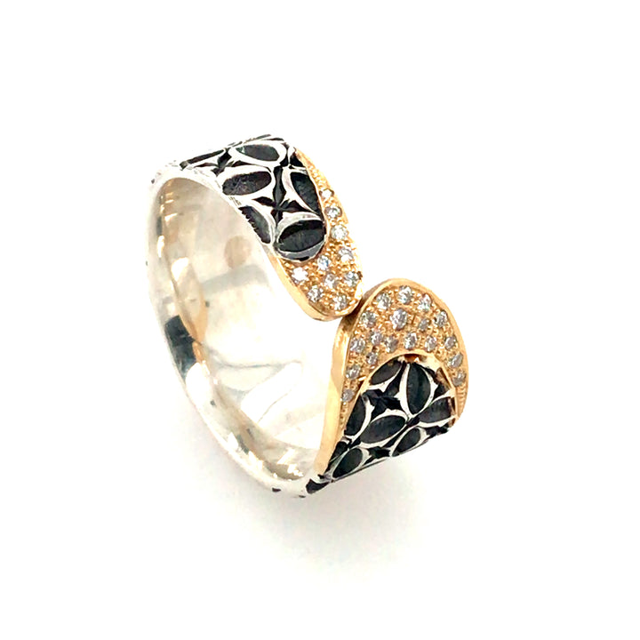 Stamped sterling silver ring. Two rounded ends meet in the middle, each capped with diamonds and 18k gold.