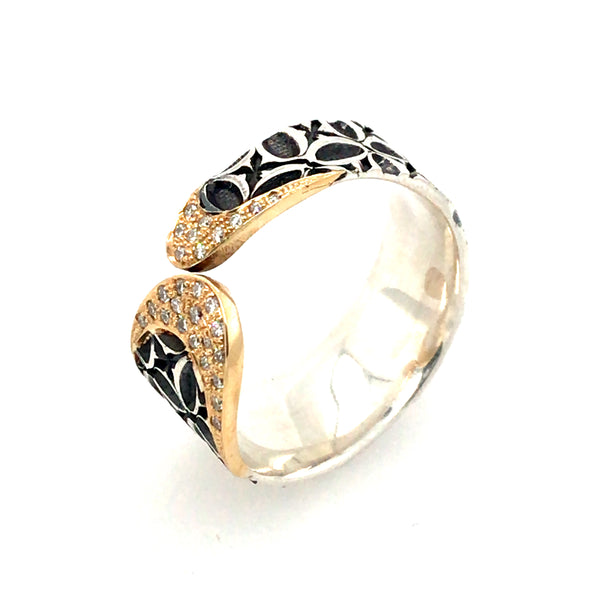 Stamped sterling silver ring. Two rounded ends meet in the middle, each capped with diamonds and 18k gold.