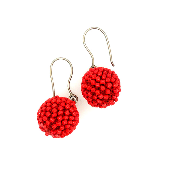 Short Orange Earrings. Red-orange glass beads are sewn in with red thread. 