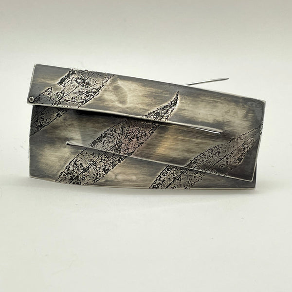 Split, hand fabricated sterling silver brooch with etched leaves, 7.5 x 3.8 cm.