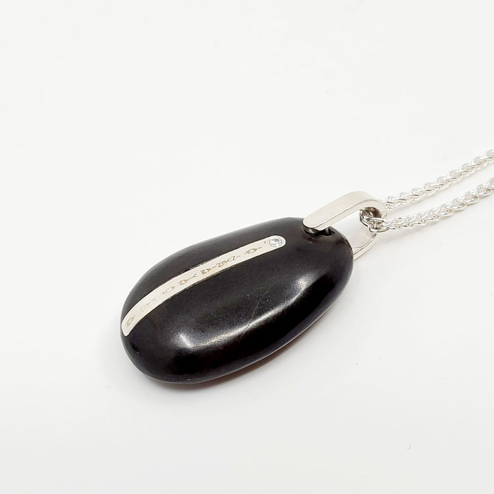Pebble pendent embedded with sterling silver engraved inlay on a 21" sterling silver wheat chain. The letters on the inlay read " aut inveniam viam aut factiam" (Latin for "I shall either find a way or make one").