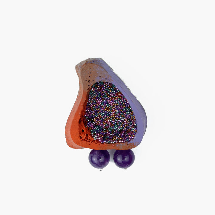 Colourful lapel pin of bovine bone in purple and orange with amethyst, glass beads, and nickel silver back.  3.3 x 4.2 x 1 cm.