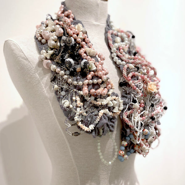 This shimmering felted neckpiece incorporates swatches of beaded fabrics and jewellery to make a bold statement. The grey felted underside is soft against the skin, with a comfortable weight.