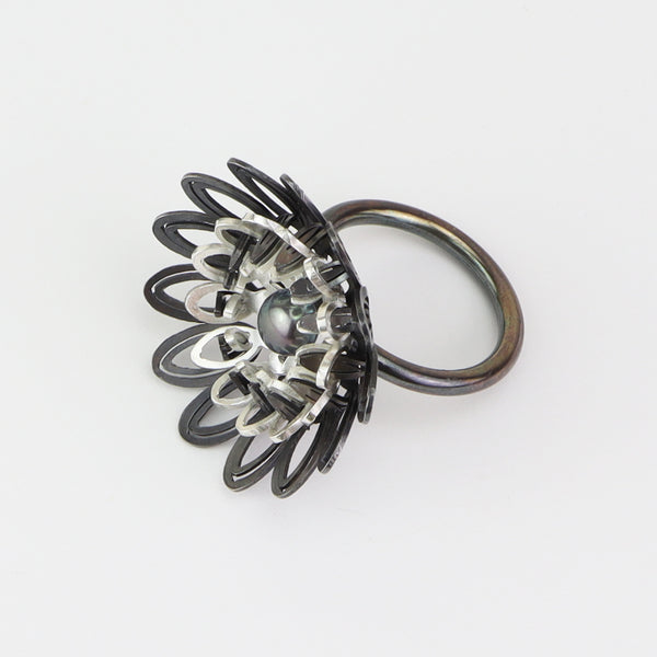 Dahlia Ring  Floral ring of sterling silver and silver with an oxide patina. The petals radiate with lively energy from the play of the negative space with the two colours.  3x3x3cm