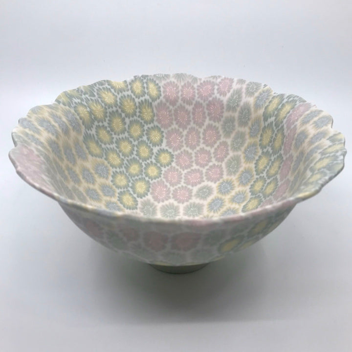 Multicolour ceramic floral bowl in pink, blue, and yellow, with delicate scalloped edges made with the nerikomi ceramic technique.