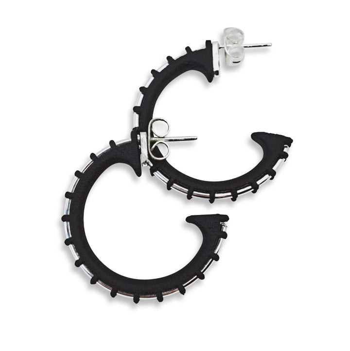 Black hoop earrings with silver accents on a white background
