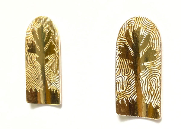 Gold leaf patterned earrings on a white background