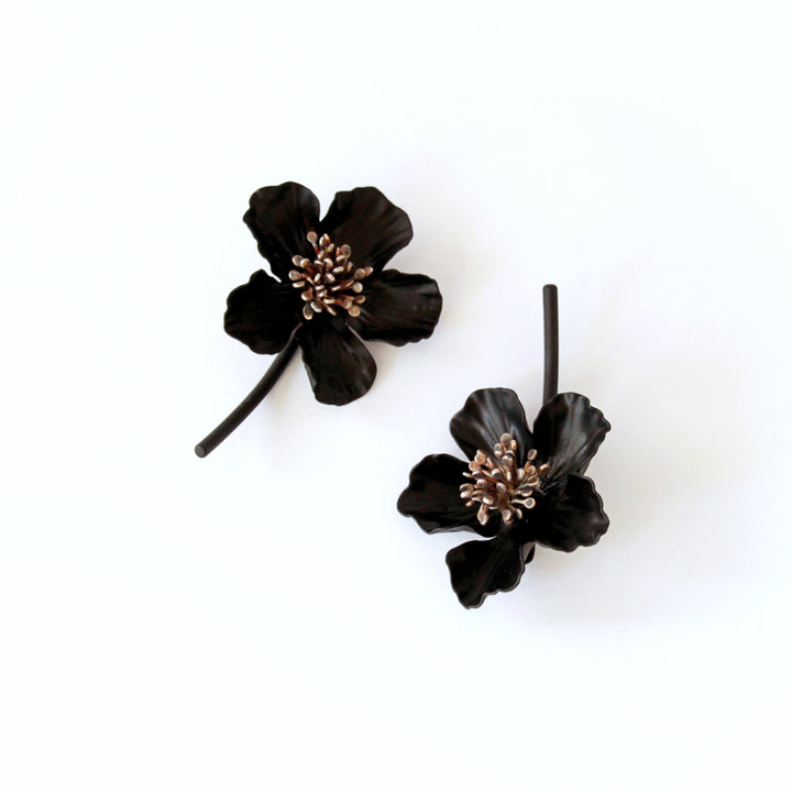 Black flower-shaped earrings on a white background