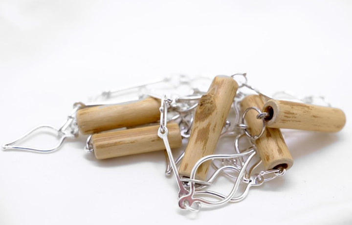 Long wood and silver leaf chain. The sterling silver links are fused and forged, and some are threaded through hollow pieces of round-leaf dogwood. The chain is 36" long so can be worn doubled.