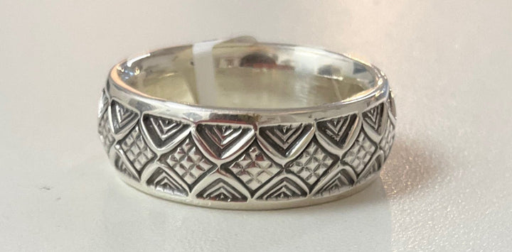 Silver ring with geometric pattern on a white background