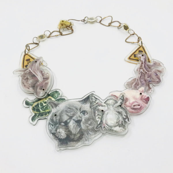 Necklace with acrylic charms of painted animals on white background.