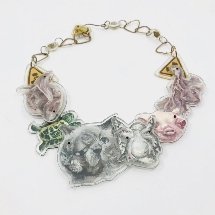 Necklace with acrylic charms of painted animals on white background.