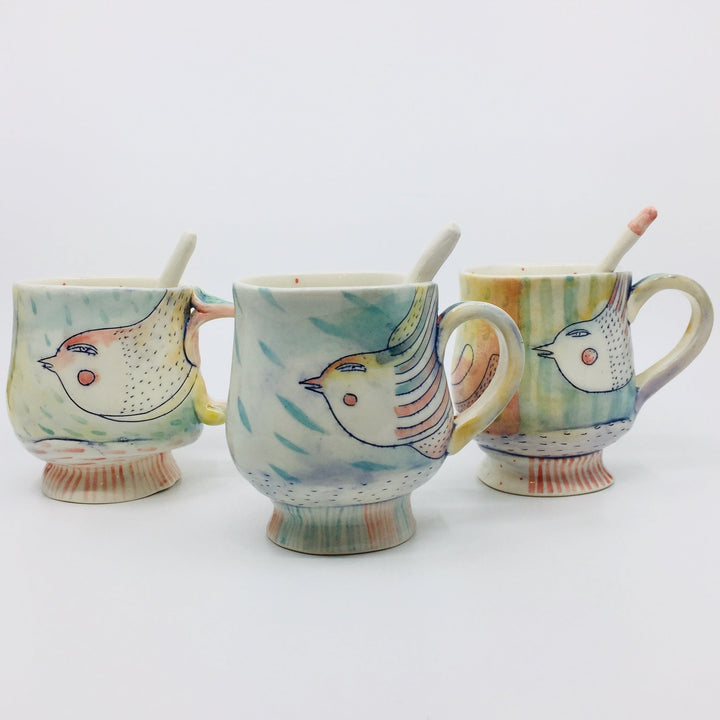 Porcelain mug finished with glazes and underglazes, with bird illustration. 
